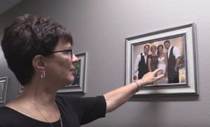 Lynette Kluver, Director of Organizational Development, shows a family picture on the wall at Alexandria Industries' new health clinic.